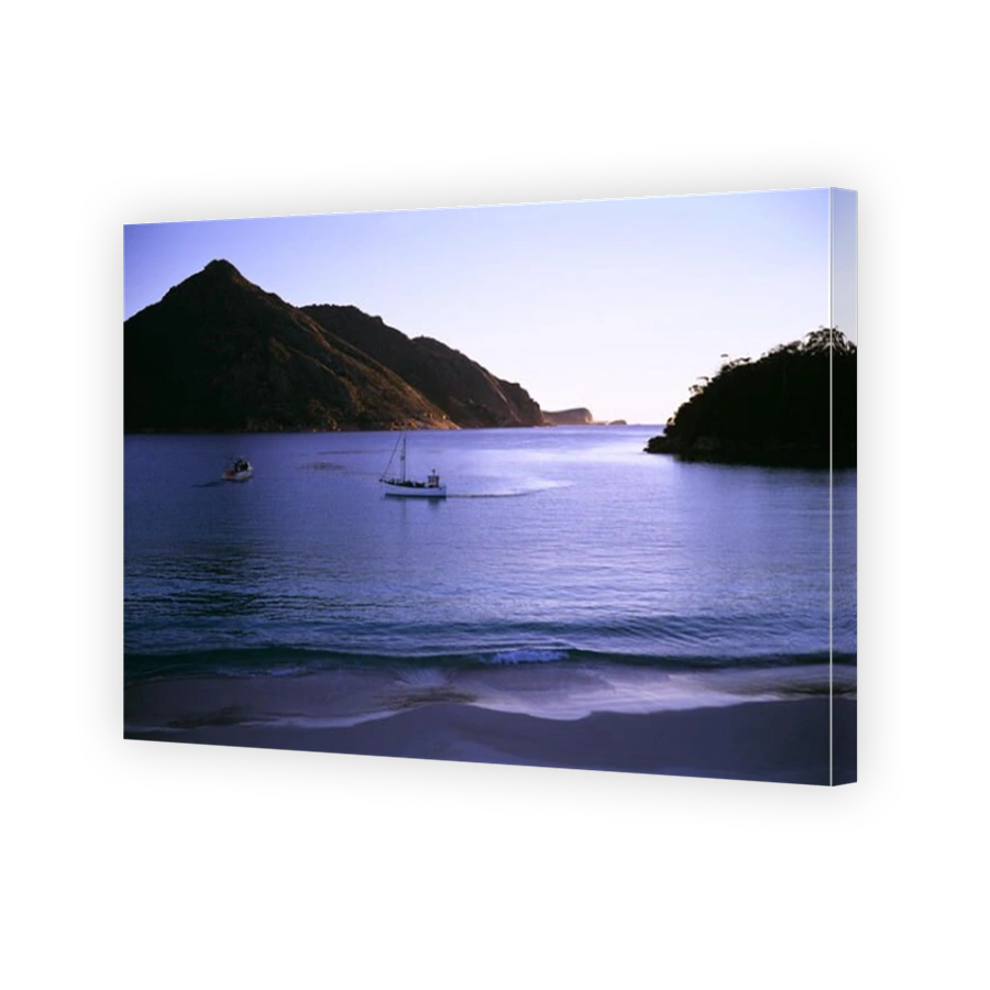 Wineglass Bay in early morning, with fishing boats. Freycinet National Park, Tasmania, Australia