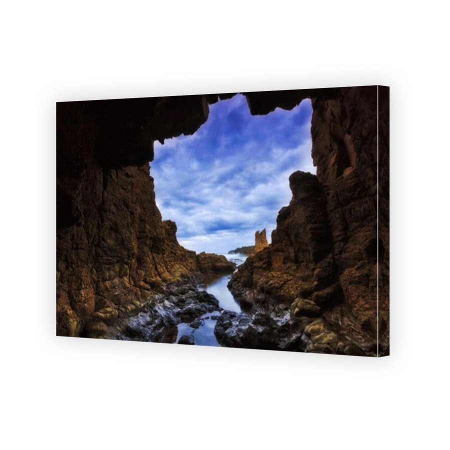 Rocky cave towards open sea at sunset near Bombo beach and Cathedral rocks of Pacific coast in Australia.
