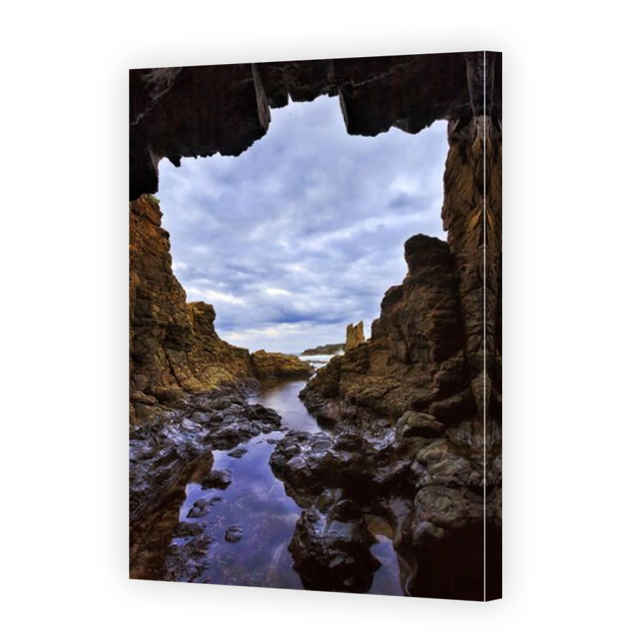Rocky isolated grotto result of sea erosion at Cathedral rocks sandstone formation of Pacific coast in Australia near Kiama during sunset.