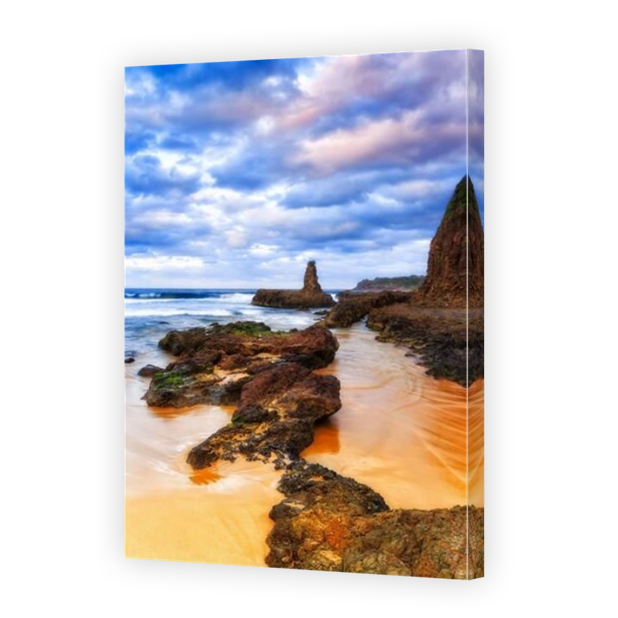 Cathedral rock and rugged terrain of basalt rock formations on Jones beach in Kiama bombo quarry site - seascape sunset.