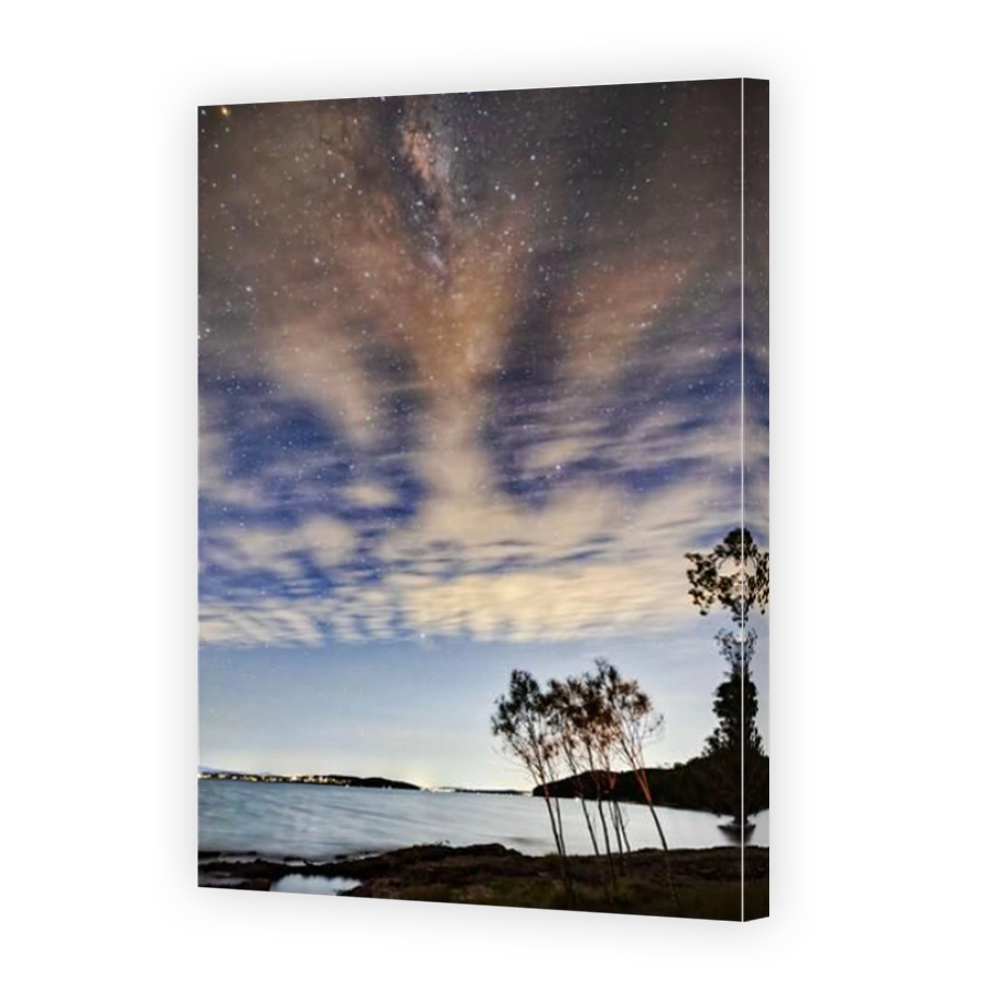 Stargazing of Milky Way over Lake Macquarie in Australia - blurry cloudy skies night landscape.