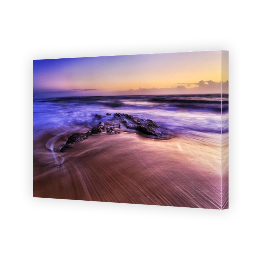 Colourful sunrise over horizon from sandy Shelly beach with rocky stone in sea tide in Nambucca Heads town of Australian pacific coast , NSW.