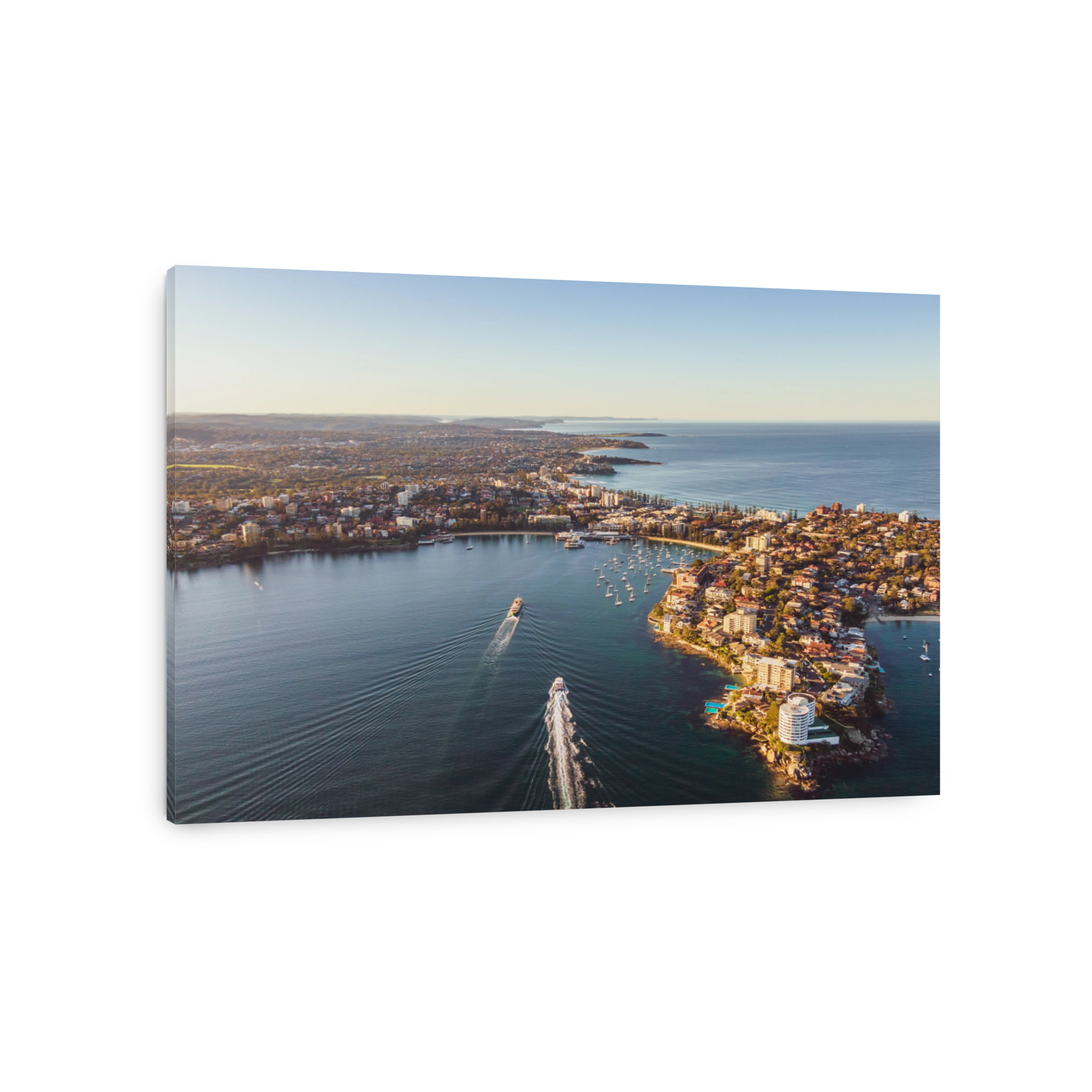 Sunset aerial drone footage of a fast ferry arriving from Sydney CBD (Circular Quay), docking at Manly Wharf pier - a 20 minute ride from the city. Manly is a beach-side suburb of Sydney, Australia.