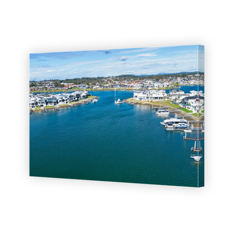 Aerial view of Hastings River and riverside Port Macquarie town in Australia under blue cloudy sky