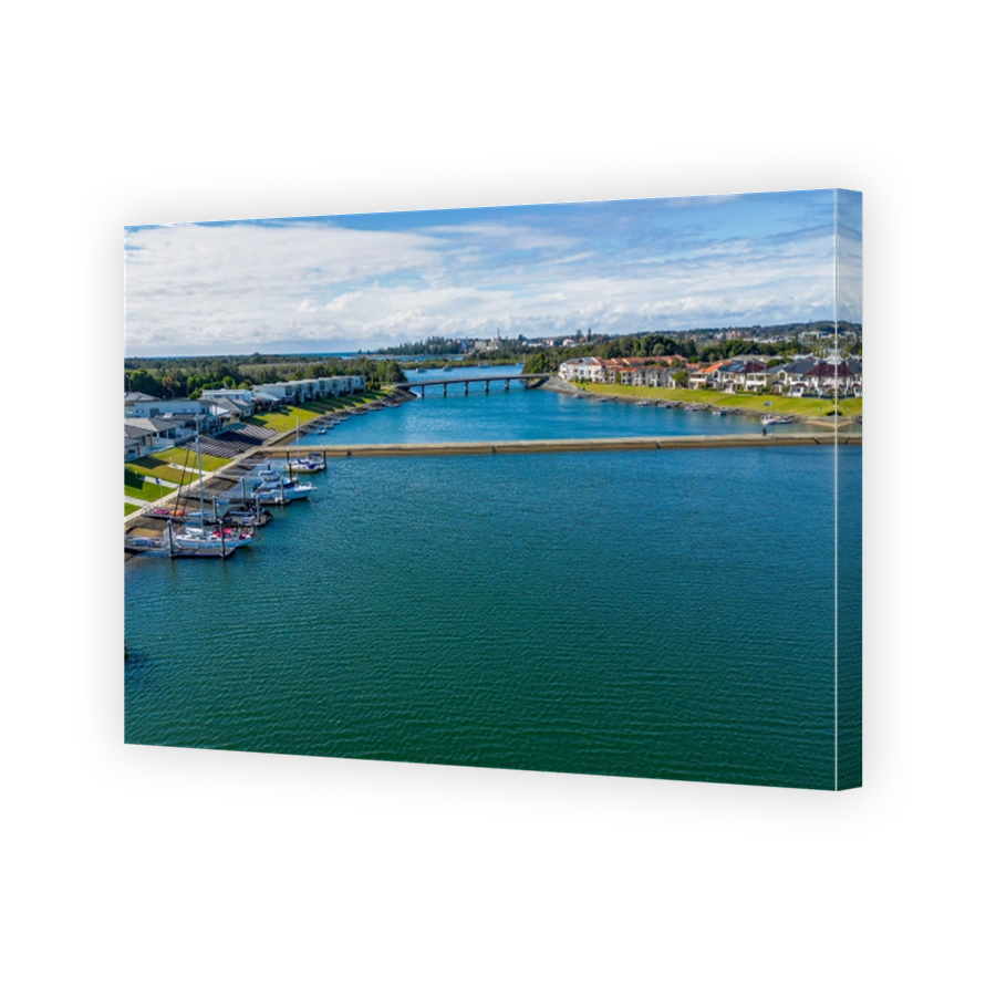 Aerial view of Hastings River and riverside Port Macquarie town in Australia under blue cloudy sky