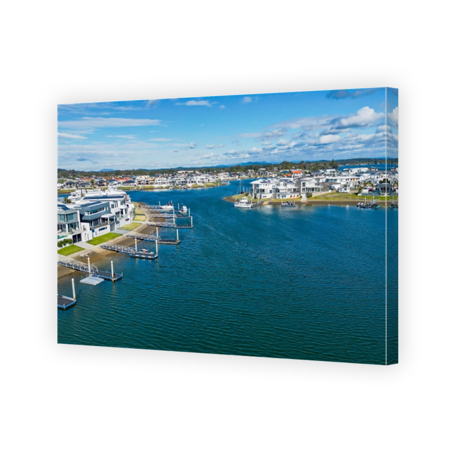 Aerial view of Hastings River and riverside Port Macquarie town in Australia under blue cloudy sky