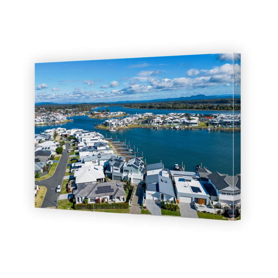Aerial view of riverside Port Macquarie town in Australia and Hastings River under blue cloudy sky