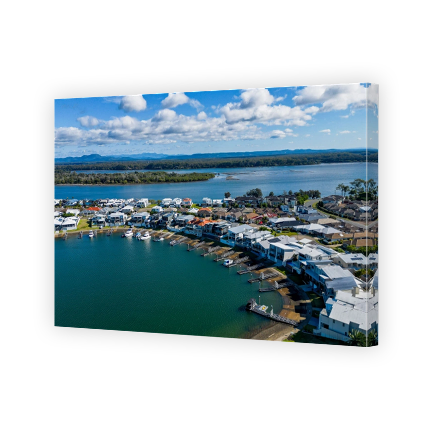 Aerial view of riverside Port Macquarie town in Australia and Hastings River under blue cloudy sky