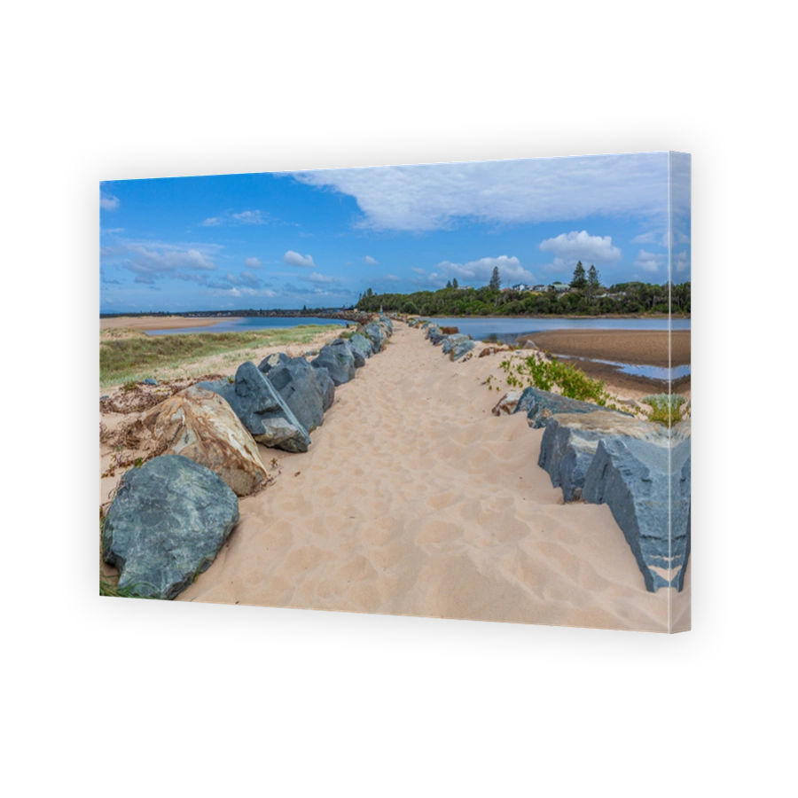 Sandy footpath among large stones near the ocean in Australia
