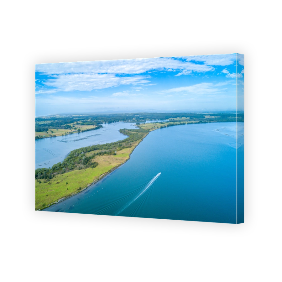 Boat sailing on the Manning River leaving water trail - aerial view