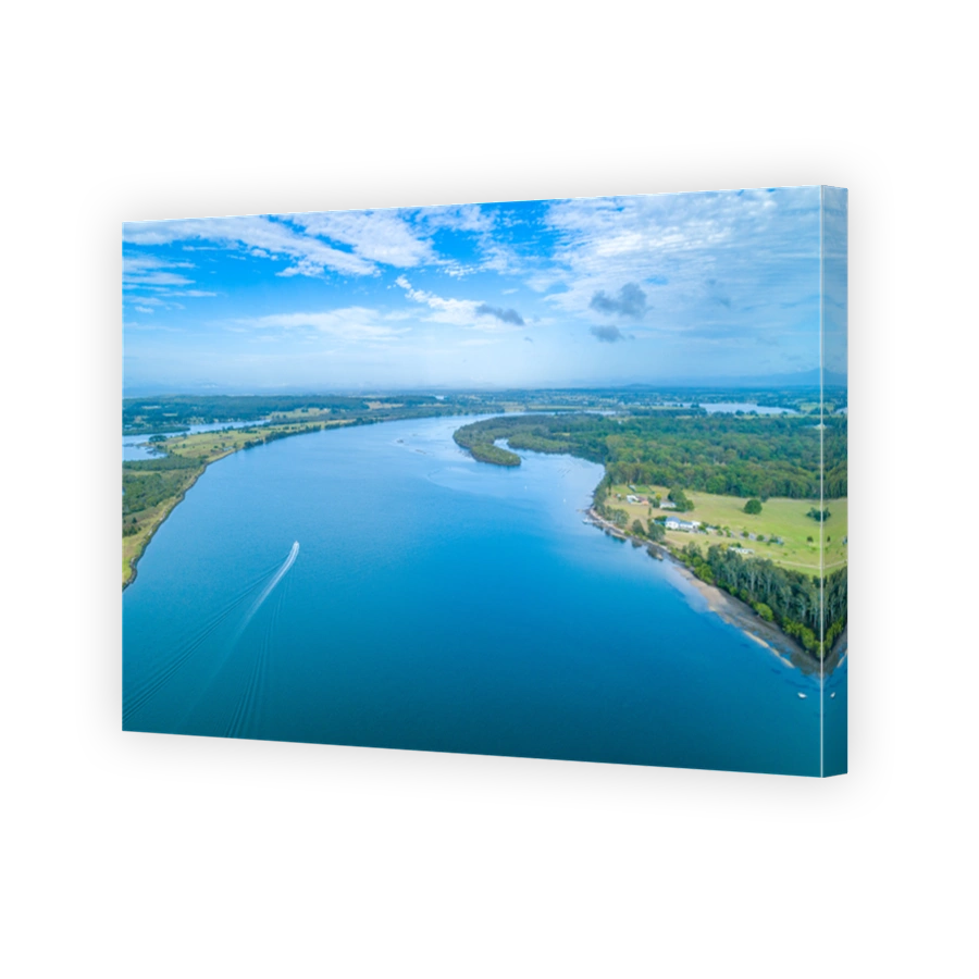 Aerial landscape of boat sailing on the Manning River leaving water trail