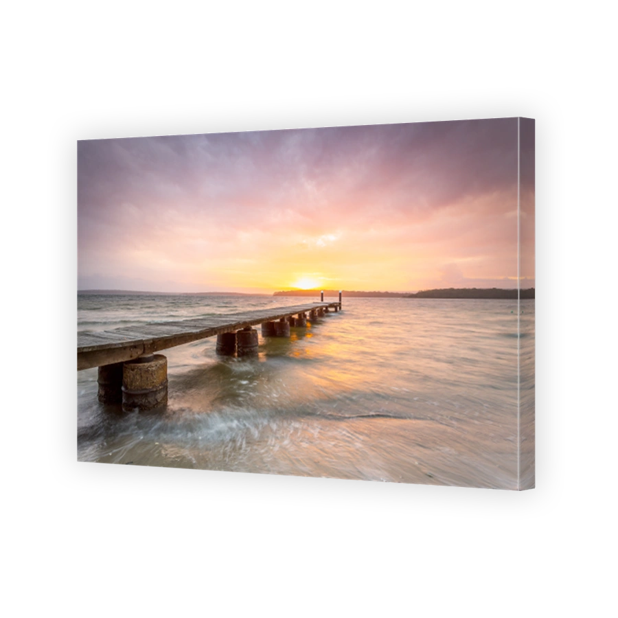 Beautiful sunset of lovely colours and a timber plank jetty on concrete pylons