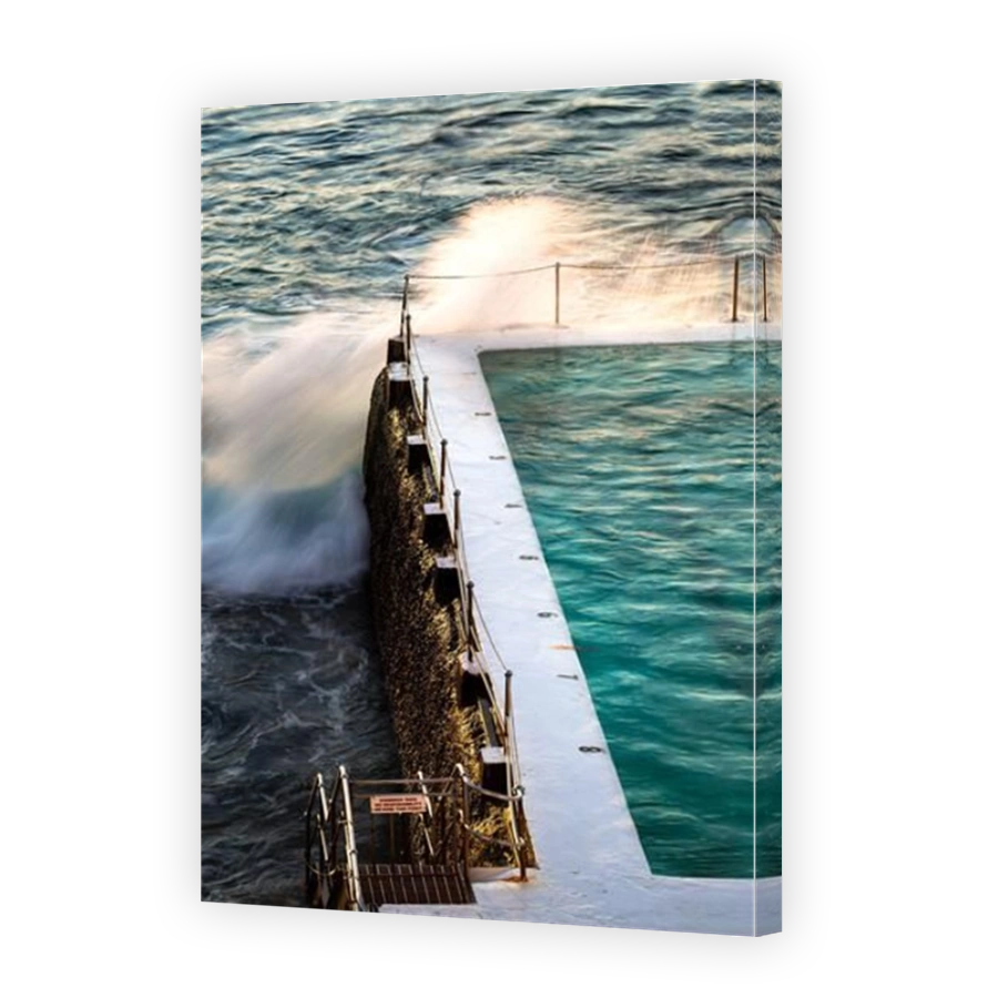 Swimming pool next to the ocean in the warm tones of sunrise in Sydney, New South Wales, Australia