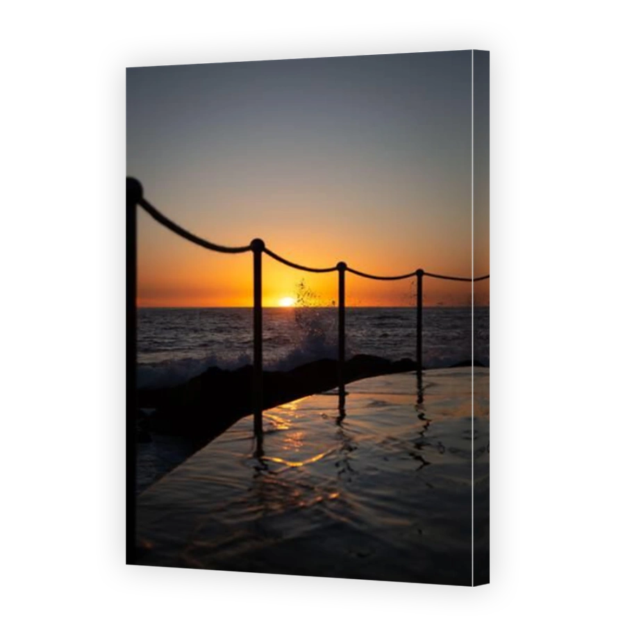 Swimming pool next to the ocean in the warm tones of sunrise in Sydney, New South Wales, Australia