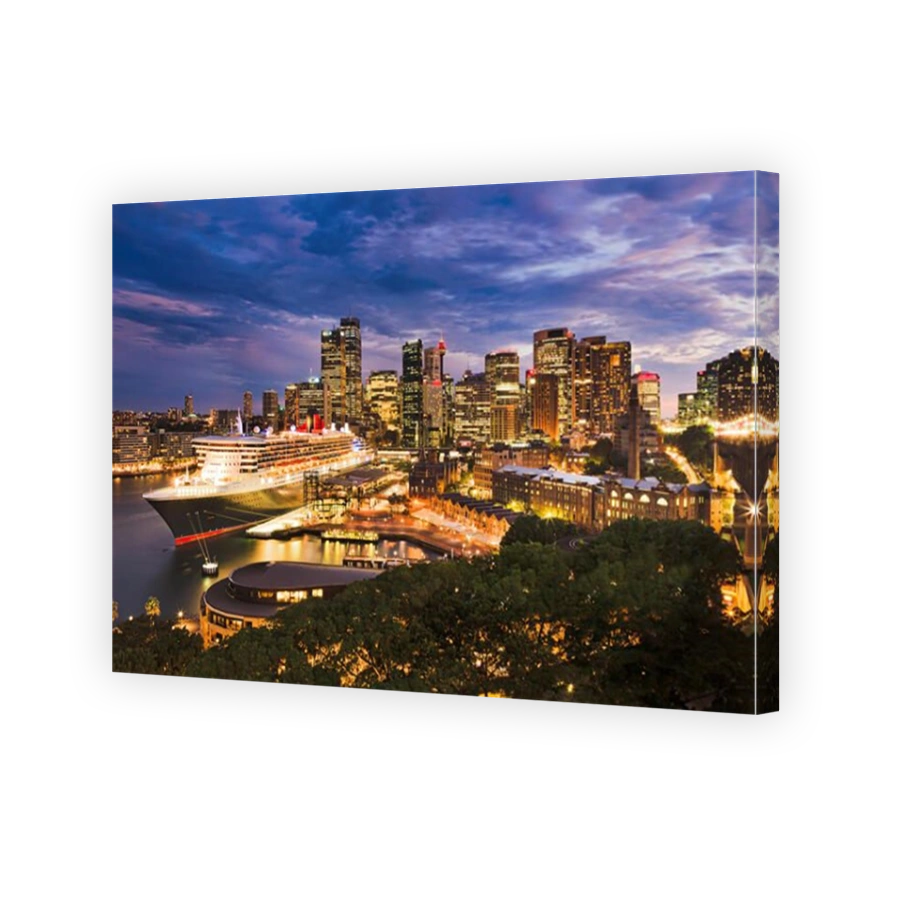 Giant passenger ship docket at overseas passenger terminal of Sydney Harbour Circular Quay against CBD skyscrapers at sunrise.
