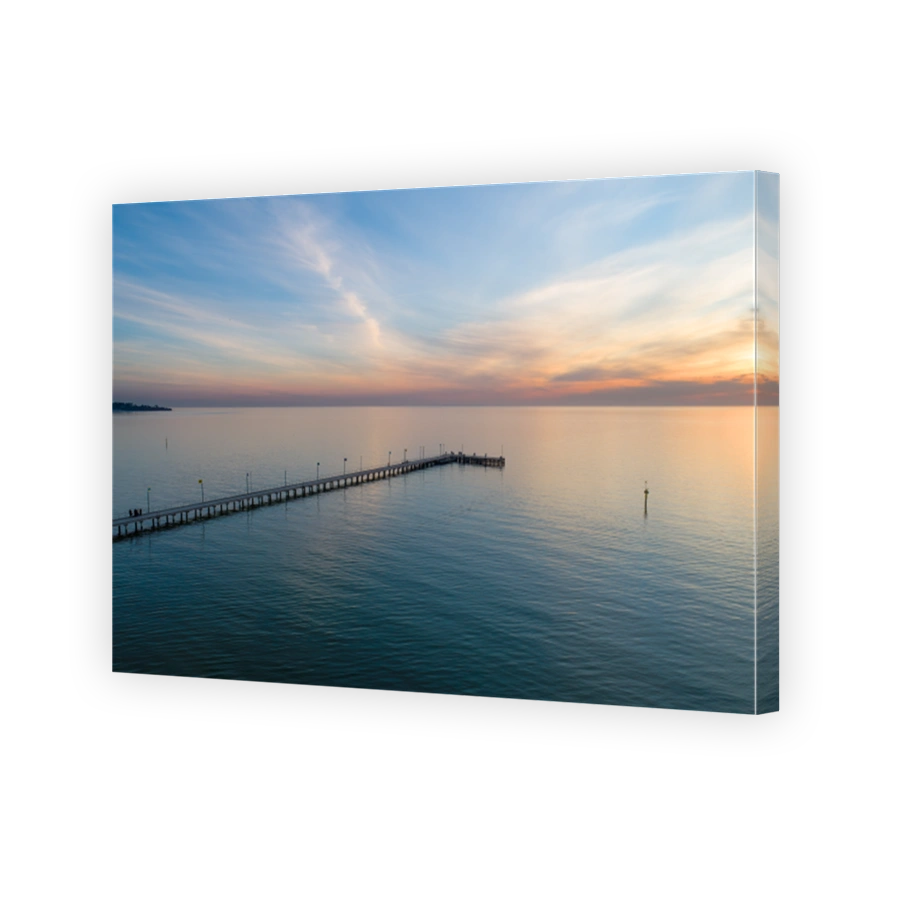 Long wooden pier at sunset - aerial view