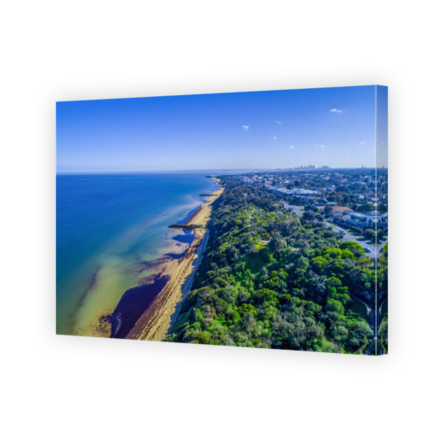 Scenic Port Phillip bay coastline with Melbourne CBD skyscrapers in the distance on bright sunny day