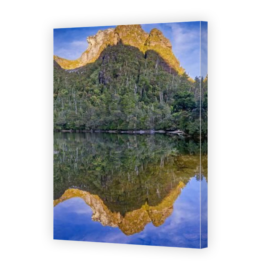 Lion's head peak reflected in Lake Tahune at sunrise below Frenchmans Cap, Franklin-Gordon Wild Rivers National Park, Tasmania, Australia