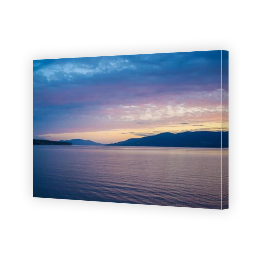 Pink and orange sunset over hills and water in Tasmania, Australia.