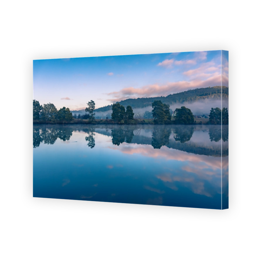 Tranquil landscape with mirror like water surface at sunrise