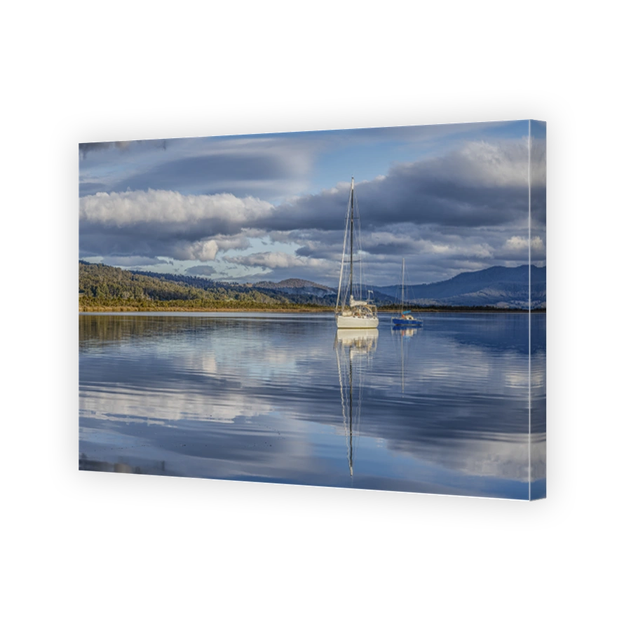 Boats, cloudscape and reflections on the Huon River at Franklin, Tasmania.