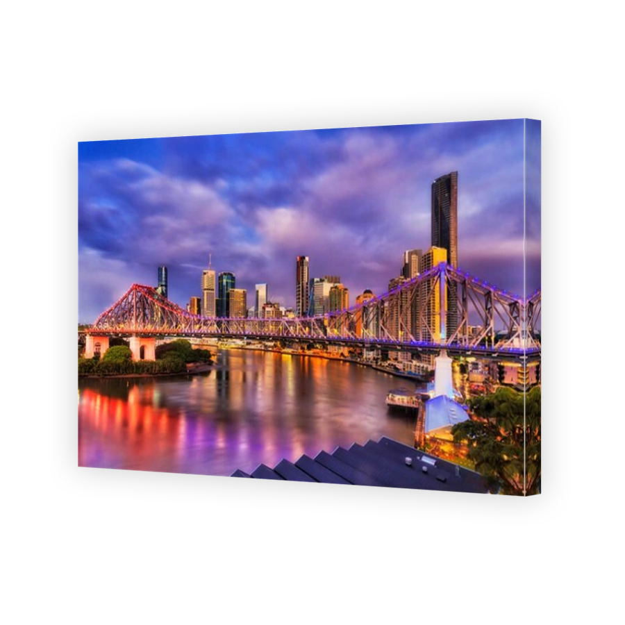 Bright lighs of Story Bridge in Brisbane city across Brisbane river in front of high-rise towers, CBD. Pre-sunrise image with reflection of illuminati