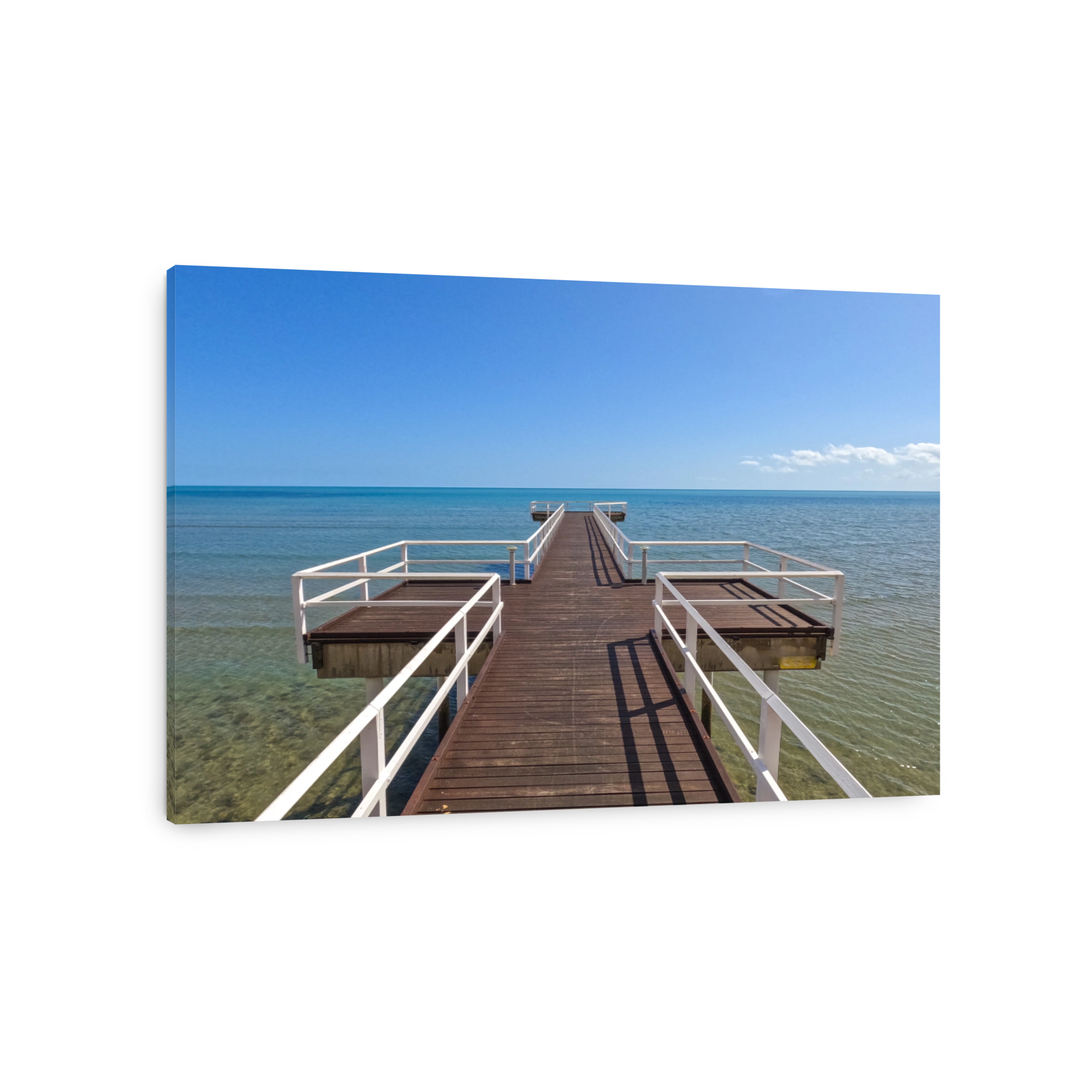 Looking out from a timber jetty Pier.  Brown timber with white hand rails.  Blue calm bay in the distance. Blue skies.  Hervey Bay Queensland Australia