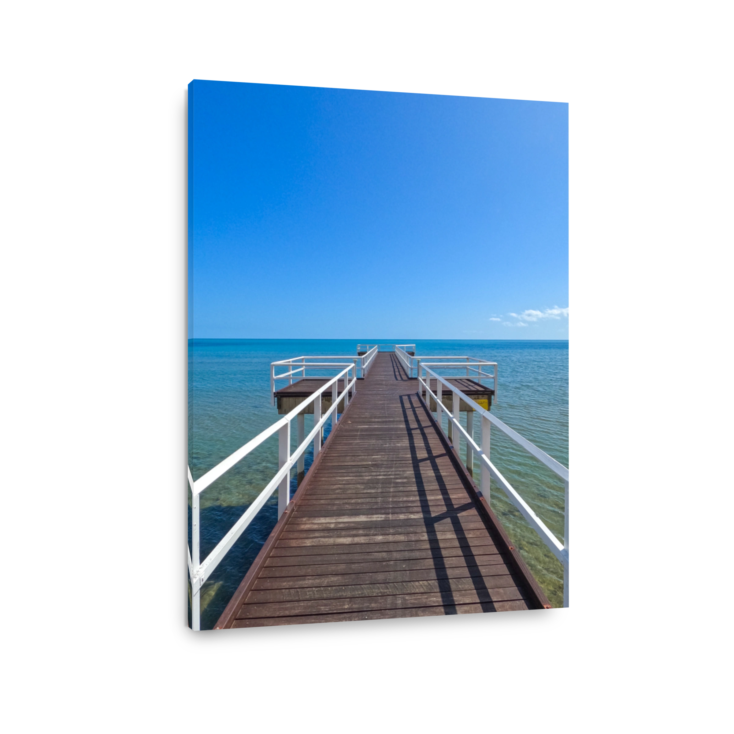 Looking out from a timber jetty Pier.  Brown timber with white hand rails.  Blue calm bay in the distance. Blue skies.  Hervey Bay Queensland Australia