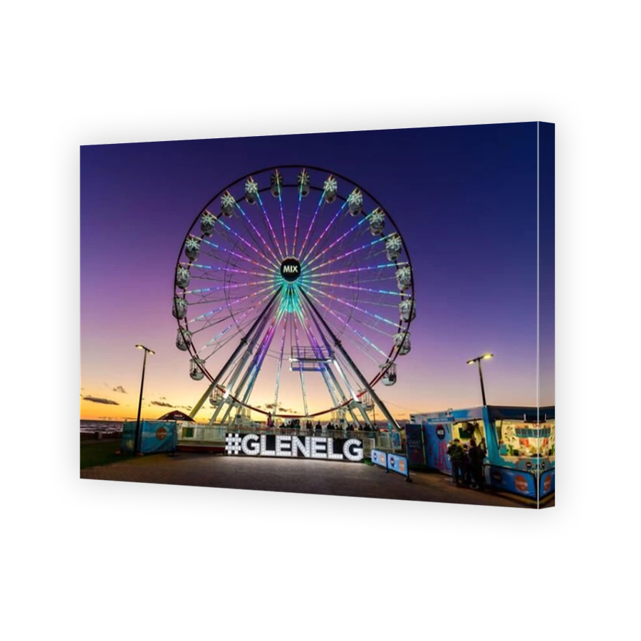 Adelaide, South Australia - February 22, 2021: Glenelg Mix102.3 Giant Ferris Wheel at Moseley Square illuminated at dusk viewed towards the beach