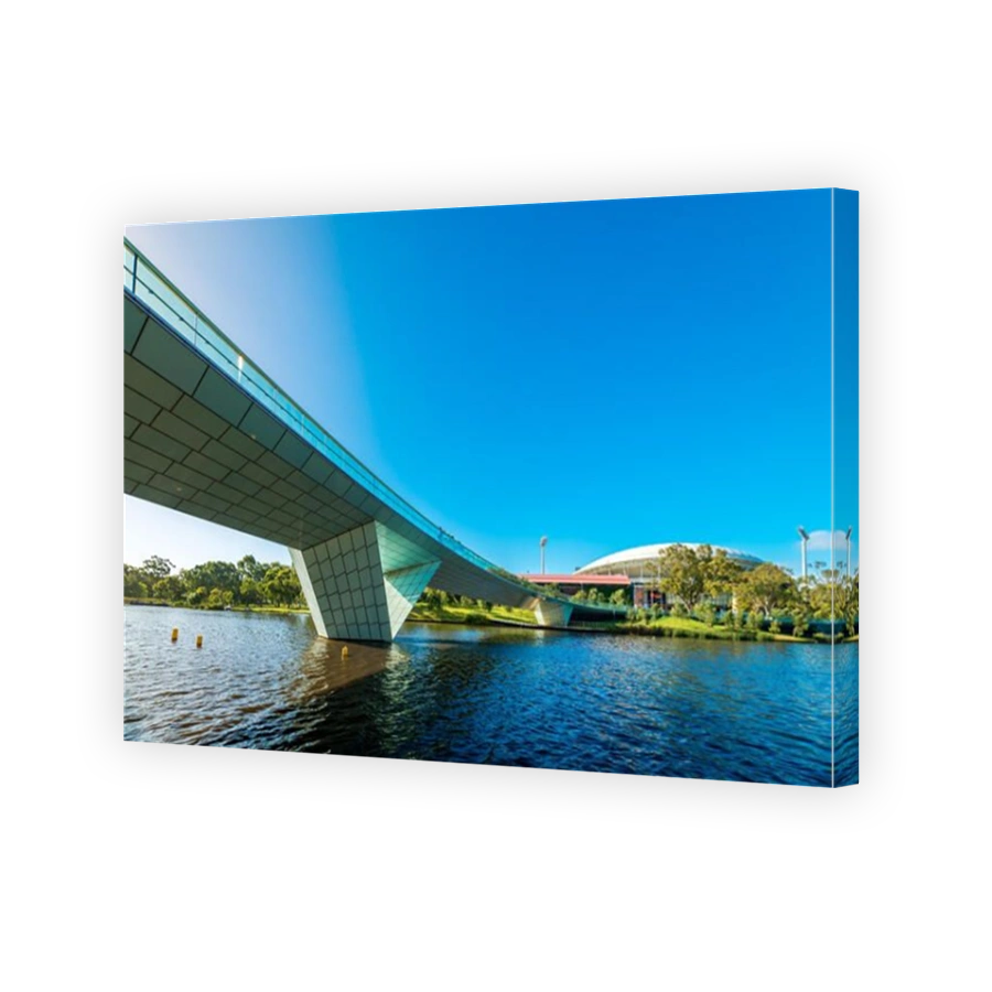 Adelaide, Australia - January 13, 2017: Iconic Torrens foot bridge with Adelaide Oval  viewed across river in Elder Park on bright day