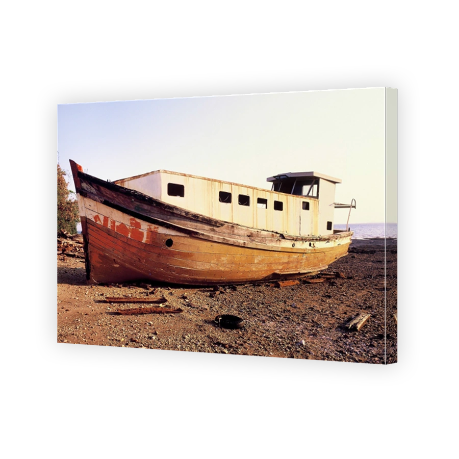 Old wooden fishing boat washed up and abandoned on the beach