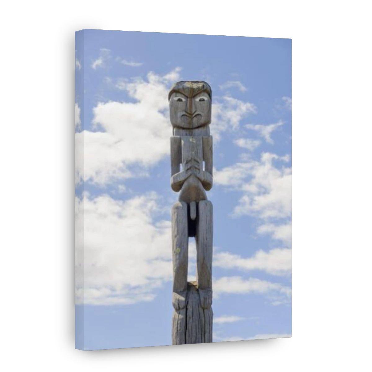 Maori traditional carved wooden pou or guardian outside a marae in New Zealand