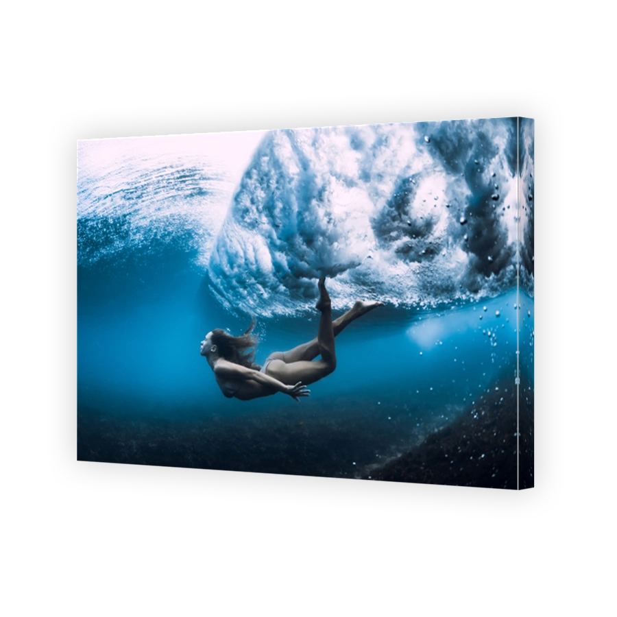 Woman swim underwater with ocean wave.