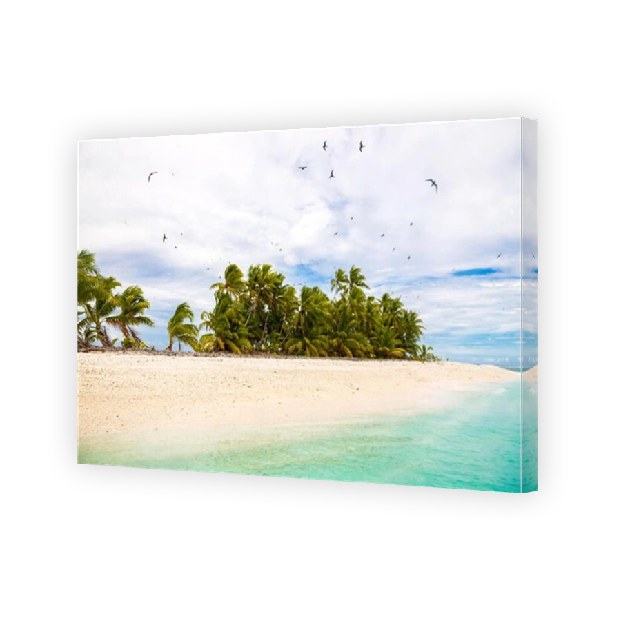 Small remote tropical island (motu) overgrown with palms in azure turquoise blue lagoon. Yellow sandy beach, big flock of birds flying above. Tuvalu.