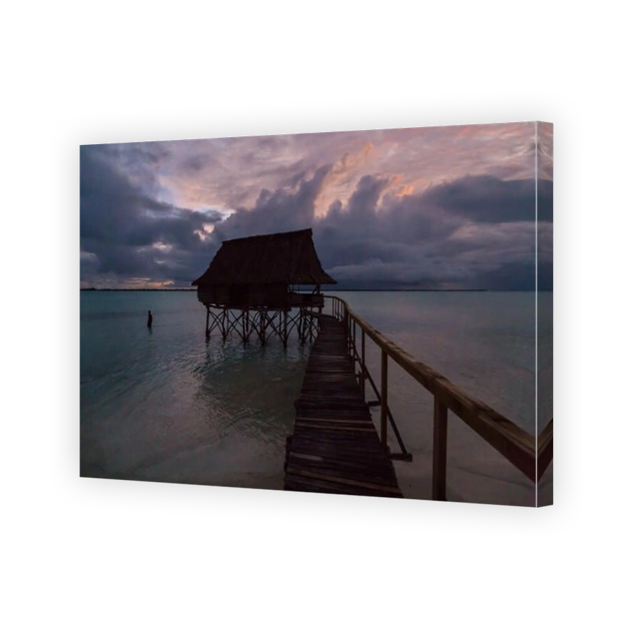 Traditional overwater thatched roof bungalow hut in lagoon of South Tarawa atoll, night, evening, twilight, sunset, Kiribati, Micronesia, Oceania.