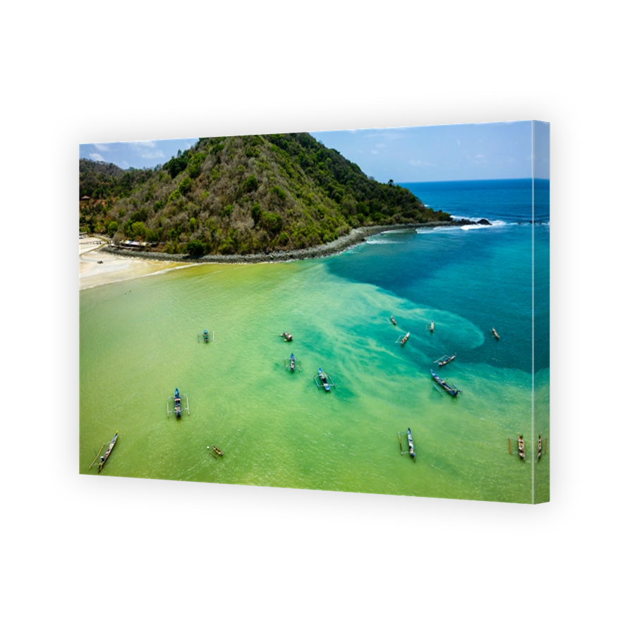 Traditional outrigger style boats in a warm, muddy ocean in Lombok, Indonesia