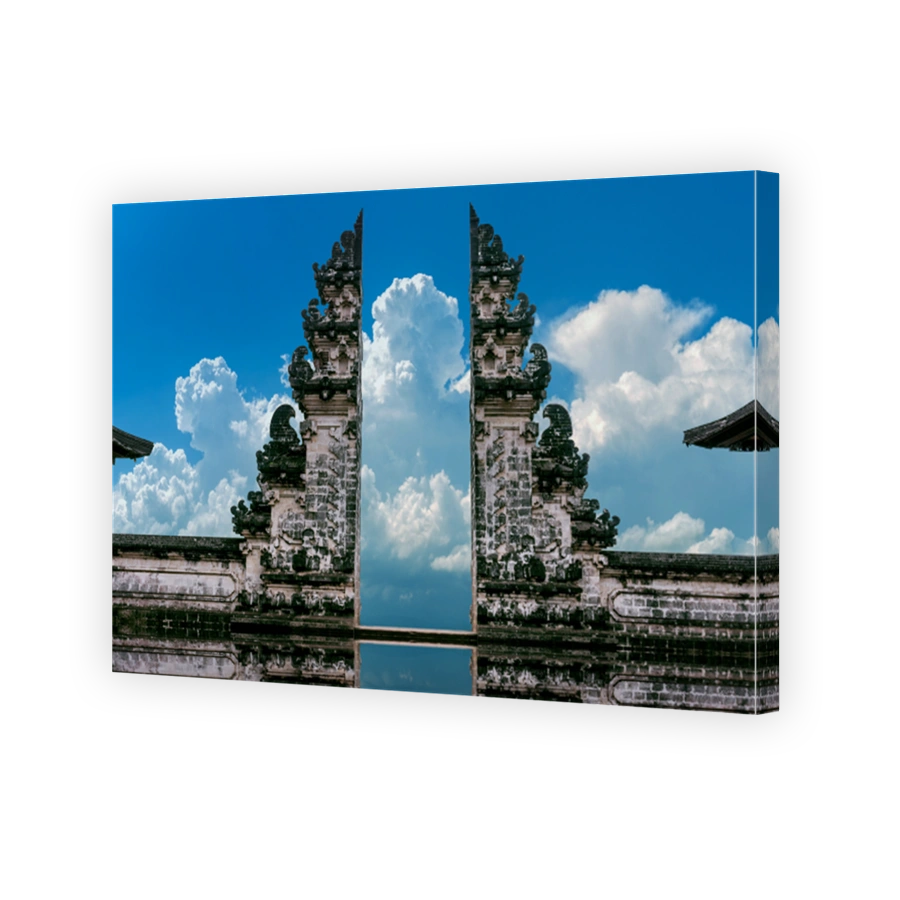 Young couple standing in temple gates and holding hands of each other at Lempuyang Luhur temple in Bali, Indonesia. Vintage tone.