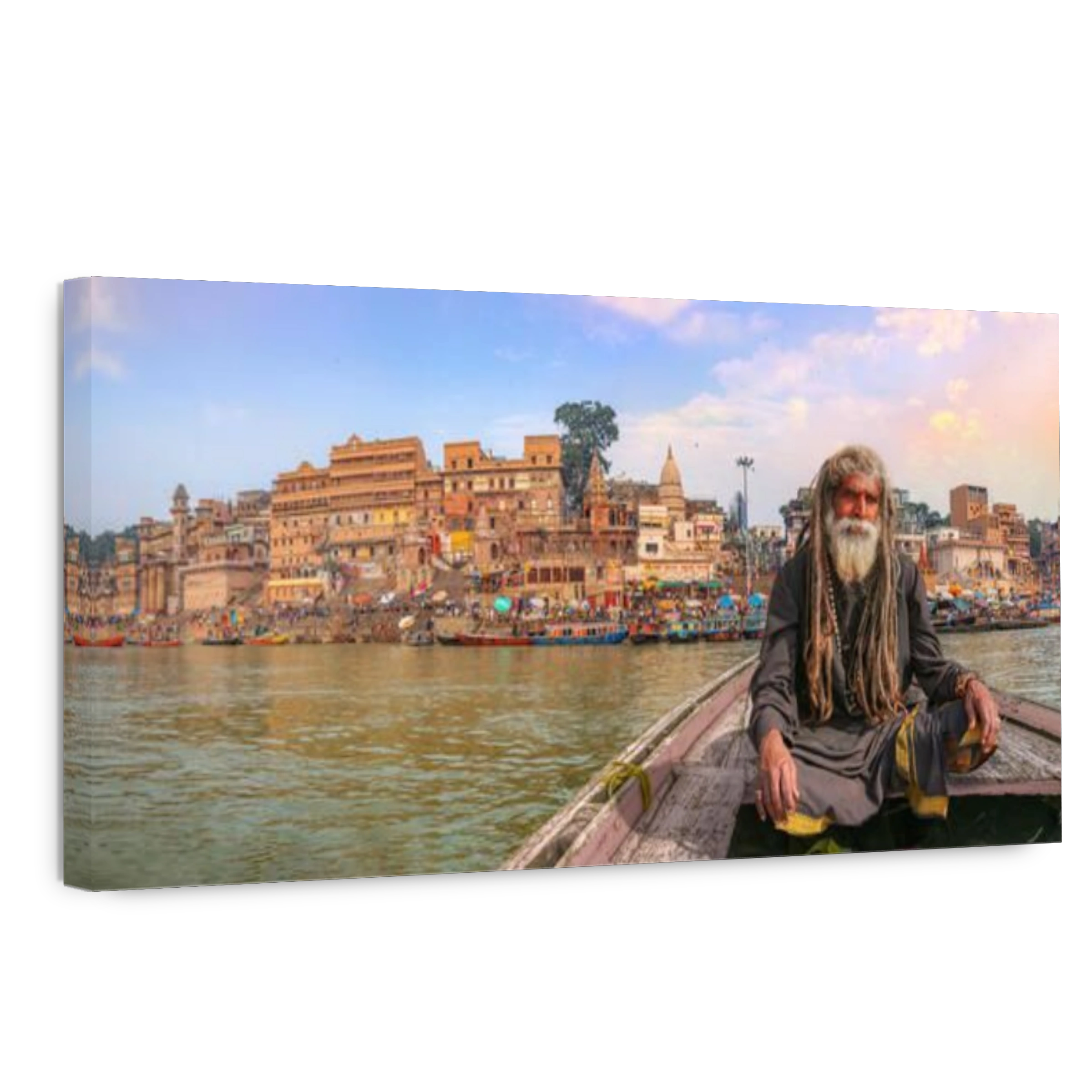 Indian Sadhu on a wooden boat on river Ganges with panoramic view of Varanasi city architecture at sunset