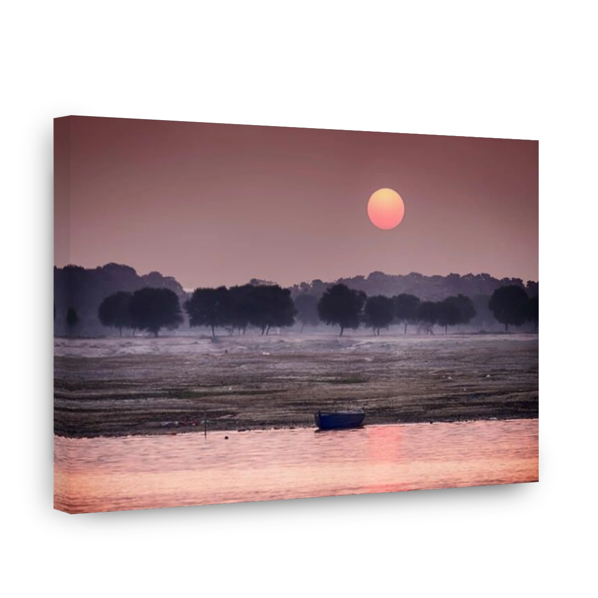 The sun rises over the eastern riverbank of the Ganges River near Varanasi, India.
