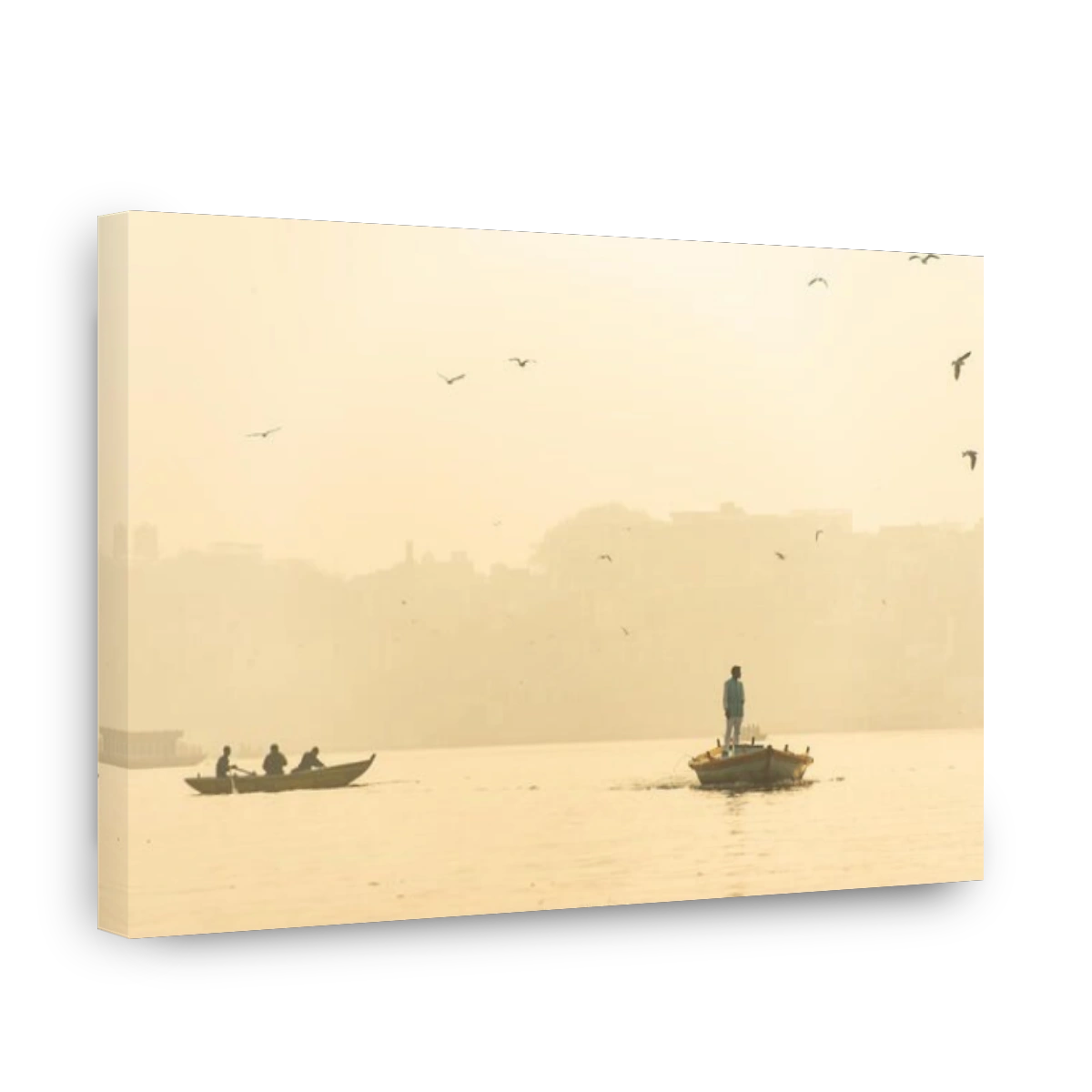A man is sailing on his wooden boat in the sacred river Ganges in the city of Varanasi during sunset.