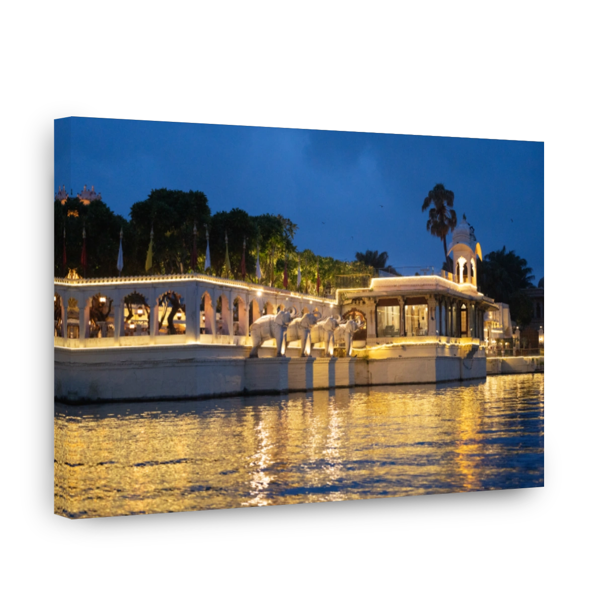 Jagmandir island palace with beautiful lights reflected in water with arches, elephant statues and arched windows in Udaipur