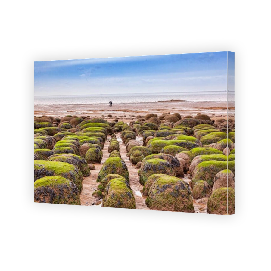 Distant couple walking on Hunstanton Beach, Norfolk, England, at low tide, in winter.