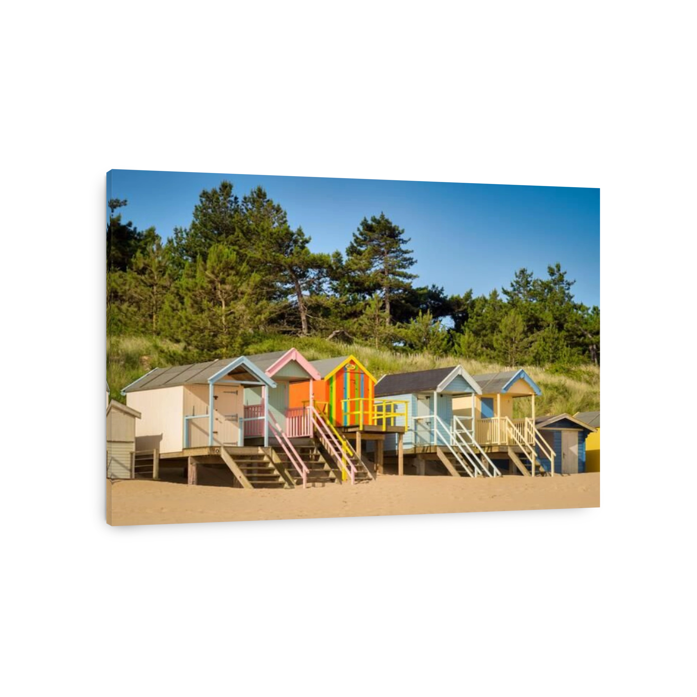29 June 2019: Wells-Next-The-Sea, Norfolk, England, UK - Bathing huts on the beach, trees behind.