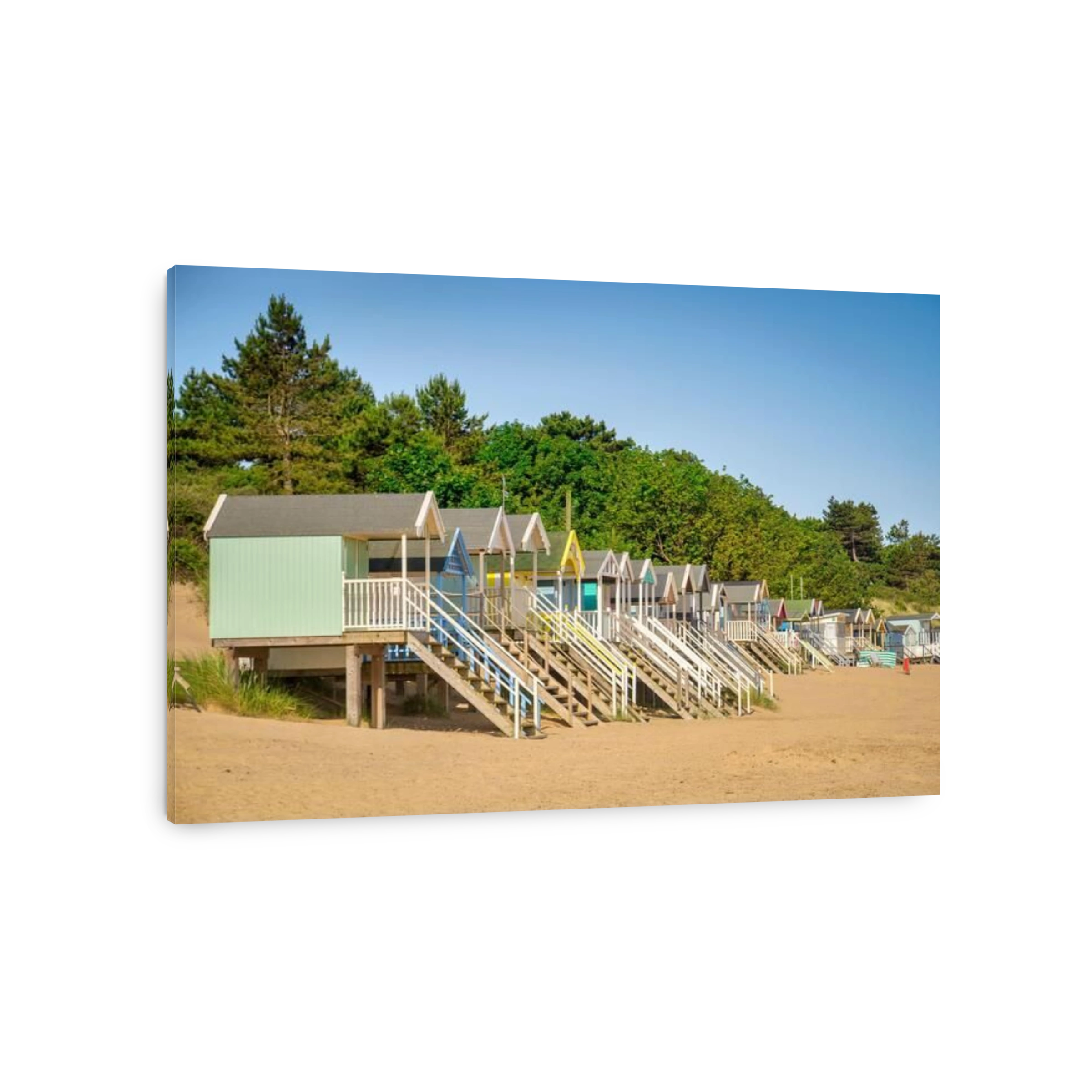 29 June 2019: Wells-Next-The-Sea, Norfolk, England, UK - Bathing huts on the beach, trees behind.