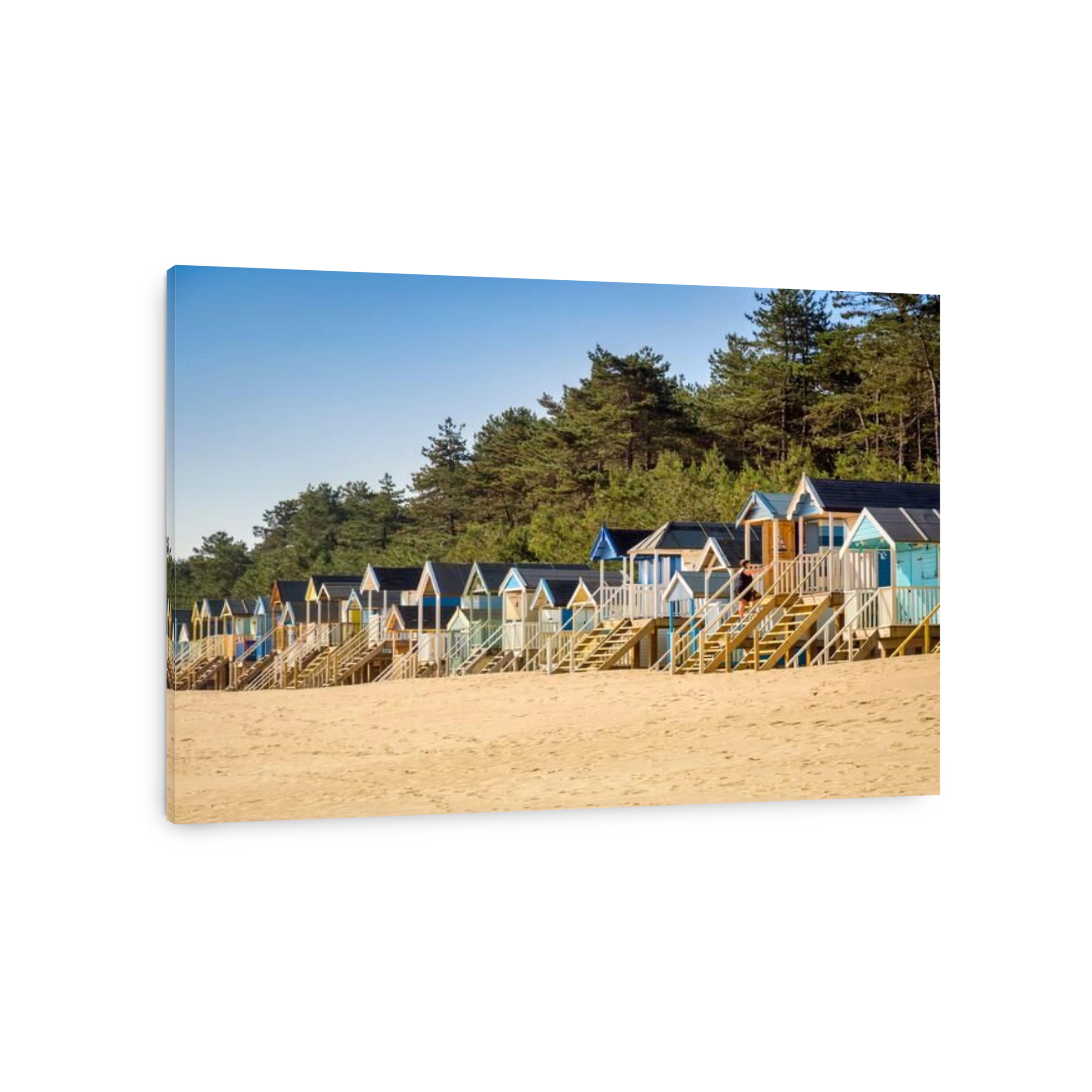 29 June 2019: Wells-Next-The-Sea, Norfolk, England, UK - Bathing huts on the beach, trees behind.