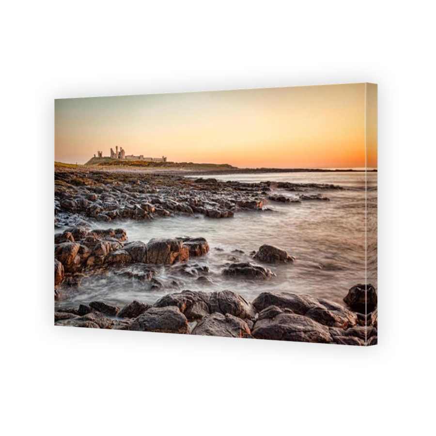 Sunrise at Dunstanburgh Castle on the Northumberland coast, North East England.