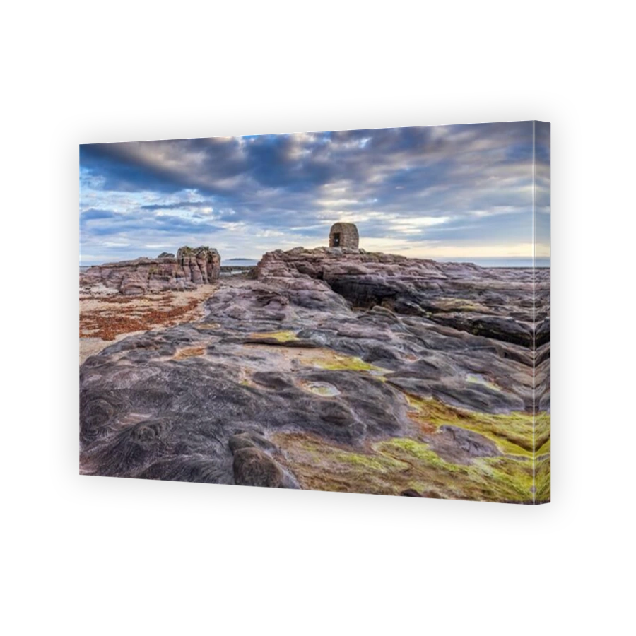 The Powder House at Seahouses on the Northumberland coast, with a dramatic morning sky.