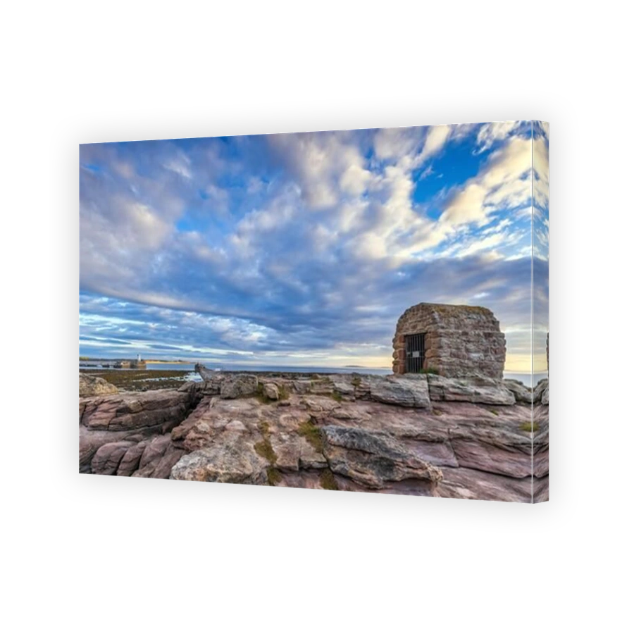 The Powder House at Seahouses on the Northumberland coast, with a dramatic morning sky.