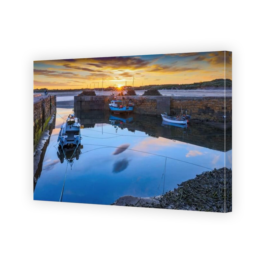 A colourful sunset at the small harbour at Beadnell, the only west-facing harbour on Northumberland's coast, England, Uk