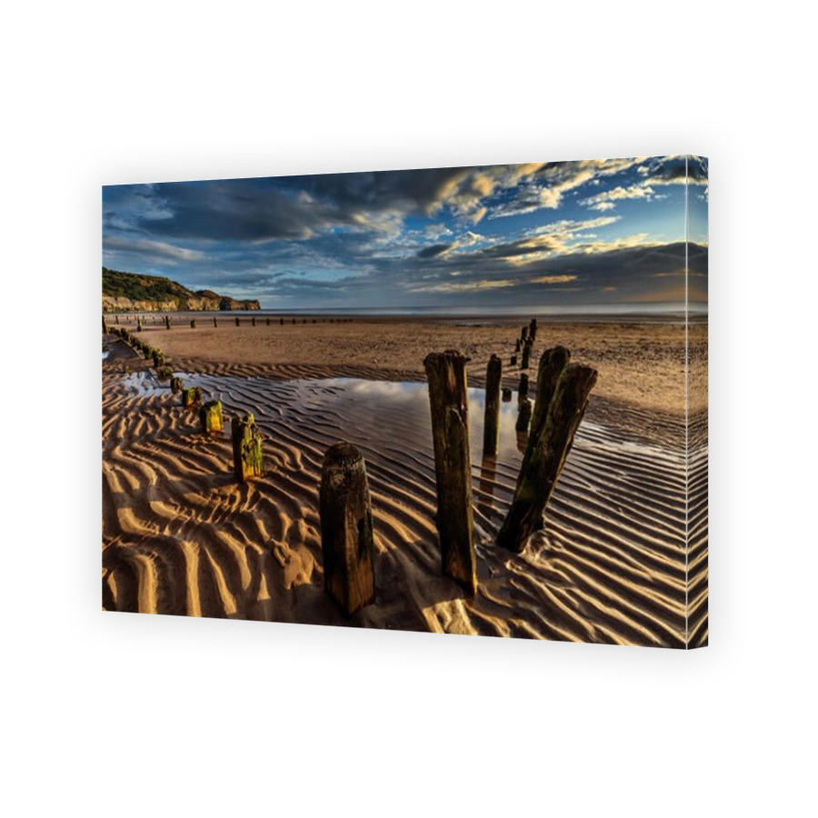 Early morning view, with remains of groynes, on the beach at the seaside village of Sandsend, near Whitby North Yorkshire England UK